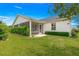 Landscaped backyard with healthy green lawn, trimmed hedges, and screened lanai at 2087 Bonneau Ln, The Villages, FL 32162