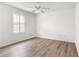 Comfortable bedroom with wood-look flooring, a ceiling fan, and a bright window at 2087 Bonneau Ln, The Villages, FL 32162