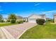 Well-maintained home in a neighborhood setting, featuring a brick driveway and neatly landscaped front yard at 2087 Bonneau Ln, The Villages, FL 32162