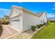 A spacious two-car garage with white siding and brick paver driveway provides ample parking at 2087 Bonneau Ln, The Villages, FL 32162