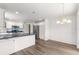 Open-concept kitchen with white cabinetry, stainless appliances, and breakfast bar overlooking the dining area at 2087 Bonneau Ln, The Villages, FL 32162
