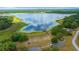 Scenic aerial view of a large lake, lush trees, parking, playground, community building, and dock at 21168 Sw Peach Blossom St, Dunnellon, FL 34431