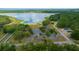 Excellent aerial shot showing the lake with a dock, mature trees, a parking area, and a community building at 21168 Sw Peach Blossom St, Dunnellon, FL 34431