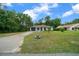 A well-maintained single-story home featuring a large front lawn, driveway, and a green garage and front door at 21168 Sw Peach Blossom St, Dunnellon, FL 34431