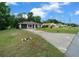 Single-story home featuring a well-kept lawn, a driveway, and a muted green garage door and entrance at 21168 Sw Peach Blossom St, Dunnellon, FL 34431