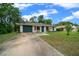Charming single-story home with a well-maintained lawn and a one-car garage with a long driveway at 21168 Sw Peach Blossom St, Dunnellon, FL 34431