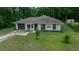 Single Gathering home with a green garage door, mature landscaping, and a well-maintained lawn at 21168 Sw Peach Blossom St, Dunnellon, FL 34431
