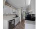 This galley kitchen features white cabinets, stainless steel dishwasher, and neutral countertops at 21168 Sw Peach Blossom St, Dunnellon, FL 34431
