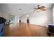 Spacious living room featuring laminate flooring, ceiling fan, and sliding glass doors to the outside at 21168 Sw Peach Blossom St, Dunnellon, FL 34431