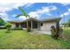 Inviting patio area, perfect for outdoor dining and relaxation, with lush greenery and tropical plants at 21168 Sw Peach Blossom St, Dunnellon, FL 34431