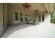Spacious covered patio featuring ceiling fans, seating, and direct access to the backyard at 2146 Se 25Th Loop, Ocala, FL 34471
