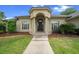 Home's welcoming entrance with arched windows, a portico, and meticulously maintained landscaping at 2146 Se 25Th Loop, Ocala, FL 34471