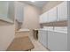Bright laundry room features updated washer and dryer, cabinets, and folding area at 2146 Se 25Th Loop, Ocala, FL 34471