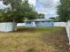 The backyard features a white privacy fence, mature trees and exterior blue siding on the home at 21570 Sw Raintree St, Dunnellon, FL 34431