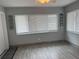 This living room features tile floors and two large windows with white blinds at 21570 Sw Raintree St, Dunnellon, FL 34431