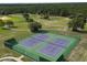 Aerial view of the community tennis courts surrounded by lush greenery and trees at 21570 Sw Raintree St, Dunnellon, FL 34431