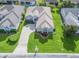 Aerial view of a well-maintained home featuring a lush green lawn, meticulous landscaping, and a concrete driveway at 2323 Nw 55Th Avenue Rd, Ocala, FL 34482