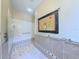 Bright bathroom with accessible features including a tiled, no-threshold shower and sturdy grab bars at 2323 Nw 55Th Avenue Rd, Ocala, FL 34482