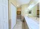 Well-lit bathroom featuring double sinks, neutral tile, and a separate toilet and shower area at 2323 Nw 55Th Avenue Rd, Ocala, FL 34482