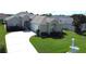 Charming home with a well-manicured lawn, lush landscaping, and a curved driveway leading to an attached two car garage at 2323 Nw 55Th Avenue Rd, Ocala, FL 34482