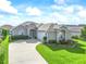 Charming single-story home boasts a well-manicured lawn, lush landscaping, and a curving driveway at 2323 Nw 55Th Avenue Rd, Ocala, FL 34482