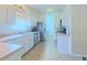 Bright white kitchen with stainless steel appliances and access to the laundry room at 2323 Nw 55Th Avenue Rd, Ocala, FL 34482