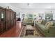 Spacious living room featuring hardwood floors, comfortable seating, and seamless transition to dining area at 2323 Nw 55Th Avenue Rd, Ocala, FL 34482