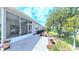 View of the backyard's concrete patio and screen enclosed lanai from ground level at 2323 Nw 55Th Avenue Rd, Ocala, FL 34482