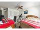 Bright bedroom with a ceiling fan, closet, red accent table and inversion table provides a functional and comfortable space at 2433 Ne 7Th St # 3, Ocala, FL 34470