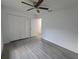 Bedroom featuring ceiling fan, large closet and gray wood floors throughout the space at 263 Oak Lane Trak, Ocala, FL 34472