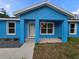 Charming blue house featuring a covered front porch with white trim and landscaping at 263 Oak Lane Trak, Ocala, FL 34472
