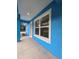 Bright blue house exterior featuring a new white window and a covered front porch entry at 263 Oak Lane Trak, Ocala, FL 34472