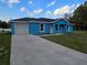 Charming blue single-story home featuring a concrete driveway and a well-manicured front yard at 263 Oak Lane Trak, Ocala, FL 34472