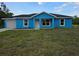 Charming blue single-story home featuring a neatly landscaped front yard and an attached garage at 263 Oak Lane Trak, Ocala, FL 34472
