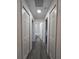 Hallway featuring gray wood floors leads to bathroom with white marbled tile tub and shower combo at 263 Oak Lane Trak, Ocala, FL 34472