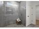 Modern shower with a frameless glass door, gray tile, and a charming teak stool at 2647 Sw 178 St, Ocala, FL 34473