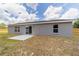 Backyard view featuring a concrete patio, windows, and glass doors, offering a great outdoor living area at 28 Olive Dr, Ocala, FL 34472