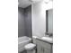 Bathroom features tub with gray tiling, white toilet, and vanity with granite countertop at 28 Olive Dr, Ocala, FL 34472
