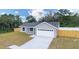 Charming single-story home featuring a two-car garage and a well-maintained lawn surrounded by trees at 28 Olive Dr, Ocala, FL 34472