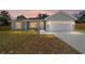 Charming single-story home with a two-car garage during twilight, creating a warm and inviting ambiance at 28 Olive Dr, Ocala, FL 34472