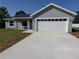 Beautiful gray single-story home with a white garage door and a well-maintained front yard at 28 Olive Dr, Ocala, FL 34472