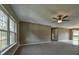 Spacious living room filled with natural light from large windows, featuring carpet floors and a ceiling fan at 3064 Sw Deerpark Heights Rd, Dunnellon, FL 34431