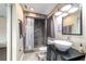 Modern bathroom featuring a vessel sink, decorative mirror, and tiled shower with river rock floor at 31 Palm Rd, Ocala, FL 34472