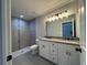 Bathroom with dual sink vanity, updated shower and modern lighting fixtures at 4162 Sw Gardenia Ct, Dunnellon, FL 34431