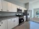 Modern kitchen showcasing white cabinets, stainless steel appliances, and granite countertops at 4162 Sw Gardenia Ct, Dunnellon, FL 34431