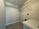 Well-lit laundry room with utility sink, hookups and shelving at 4162 Sw Gardenia Ct, Dunnellon, FL 34431