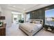 Serene main bedroom featuring tray ceilings, a sitting area, and large windows with scenic water views at 4164 Sw 53Rd Lane Rd, Ocala, FL 34474