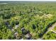 An aerial view shows several homes in the neighborhood surrounded by lush green trees and spacious lots at 5092 Sw 197Th Ter, Dunnellon, FL 34431
