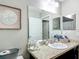 This bathroom features a toilet, a sink with a dark cabinet base, and a large mirror with art on the wall at 5092 Sw 197Th Ter, Dunnellon, FL 34431