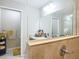 This is a bathroom featuring tile walls, a sink, a large mirror, and a toilet in a separate room at 5092 Sw 197Th Ter, Dunnellon, FL 34431